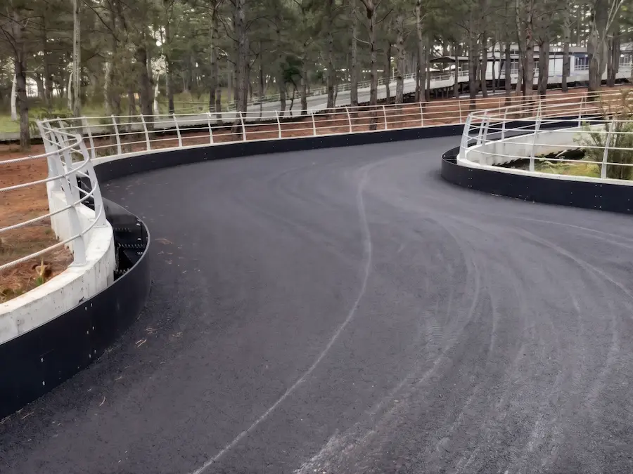 Professional go-kart track safety barrier system by China manufacturer SAIDI KART, installed at a scenic outdoor track in Dalat.